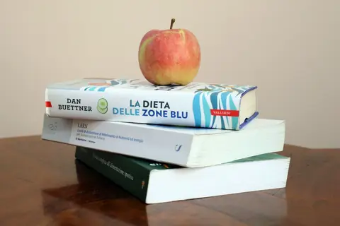 Una mela su una pila di libri di nutrizione